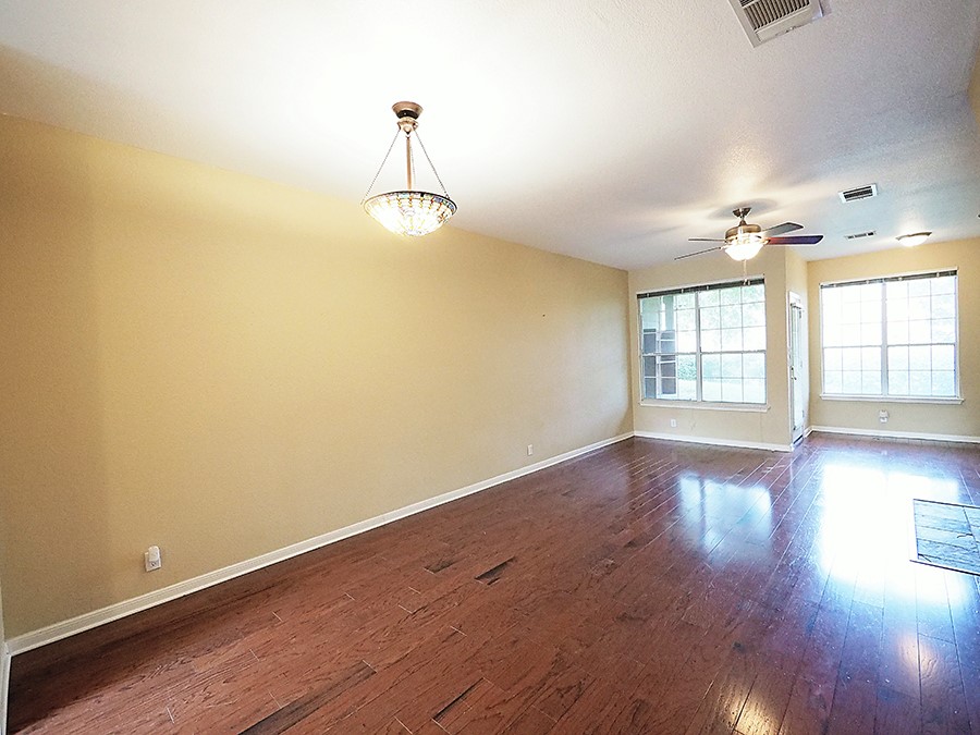 12401 Los Indios Trail, Unit 13 Austin, TX 78729 - Photo 2 of 27 a view of empty room with wooden floor and fan