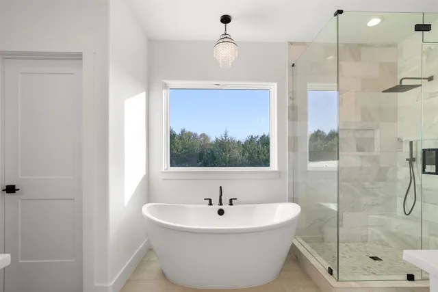 a bathroom with a double vanity sink a mirror a bathtub and shower