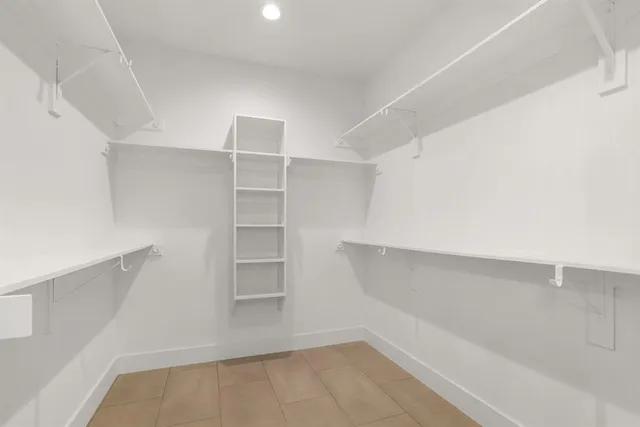 an empty room with wooden floor ceiling fan and windows