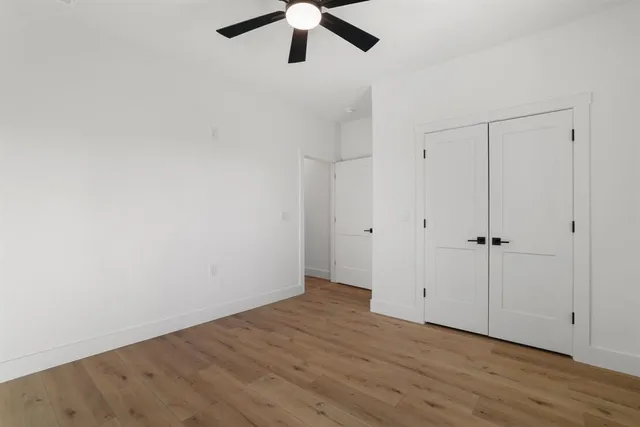 a view of a hallway with closet and wooden floor