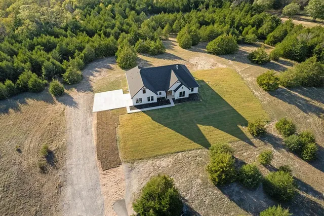an aerial view of a house with a yard