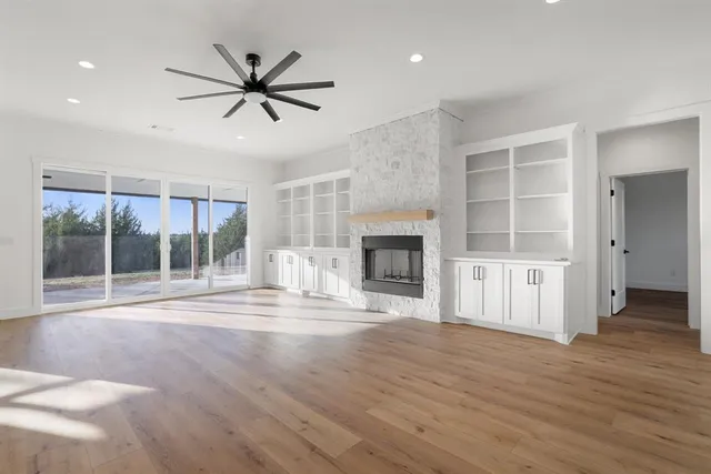 a view of an empty room with a fireplace and a window
