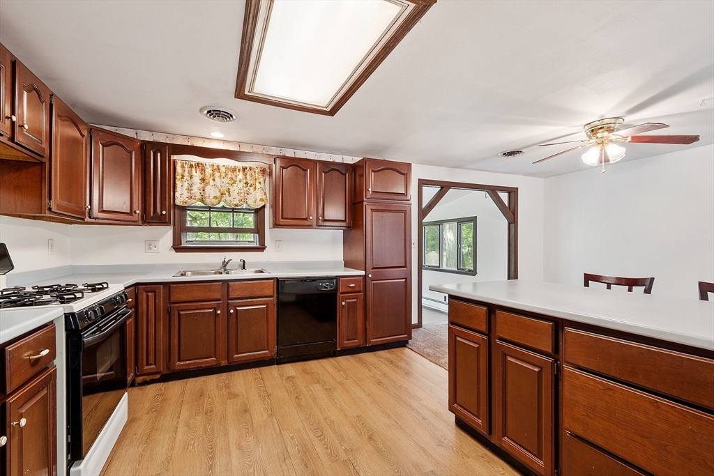 25 Cushing Street Salisbury, MA 01952 - Photo 14 of 40 a kitchen with stainless steel appliances granite countertop a stove a sink dishwasher and a microwave oven with cabinets