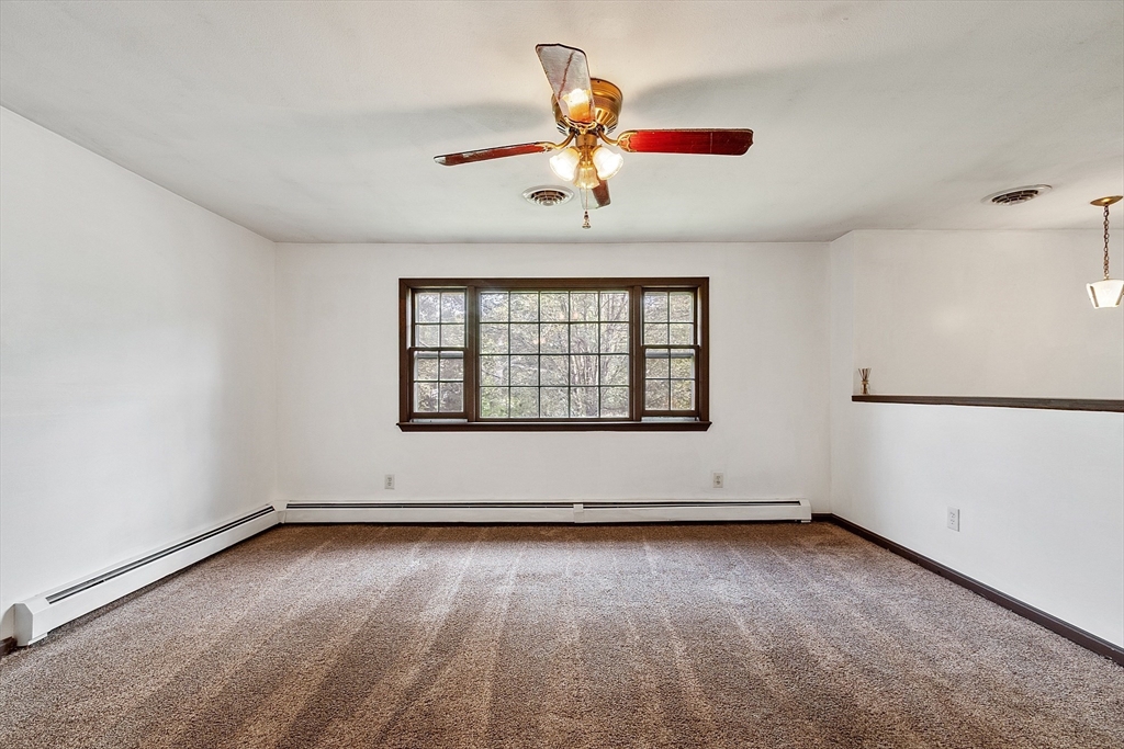 25 Cushing Street Salisbury, MA 01952 - Photo 9 of 40 an empty room with chandelier fan and windows