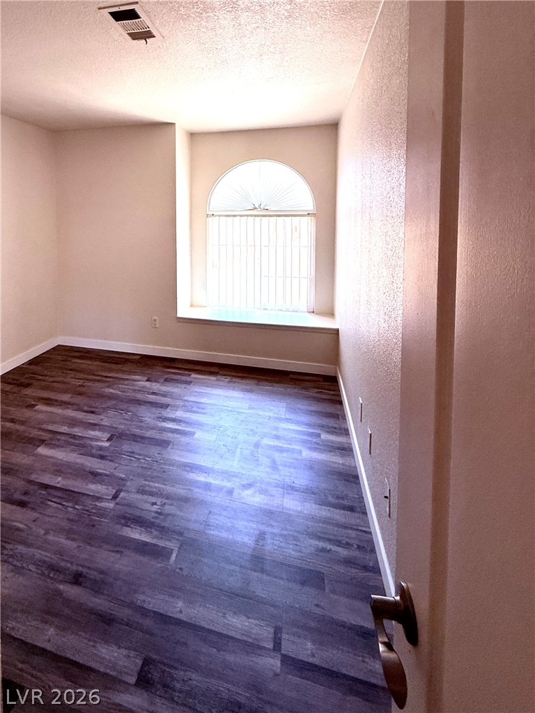 9325 West Desert Inn Road, Unit 260 Las Vegas, NV 89117 - Photo 16 of 42 A graceful arched window illuminates the durable wood-look flooring, offering versatile interior space.