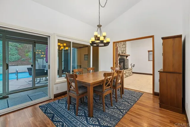 a dining room with furniture a chandelier and wooden floor