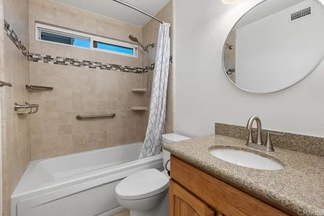 a bathroom with a granite countertop toilet a sink and a mirror