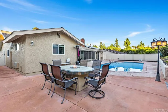 a view of a patio with table and chairs with wooden fence