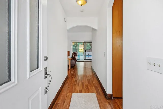 a view of a hallway with wooden floor and furniture