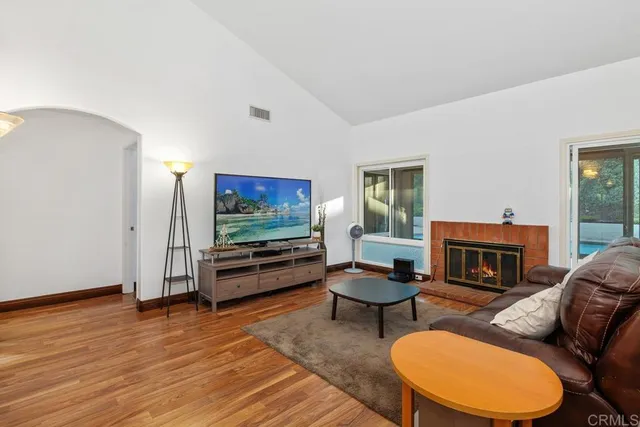 a living room with furniture a flat screen tv and a fireplace