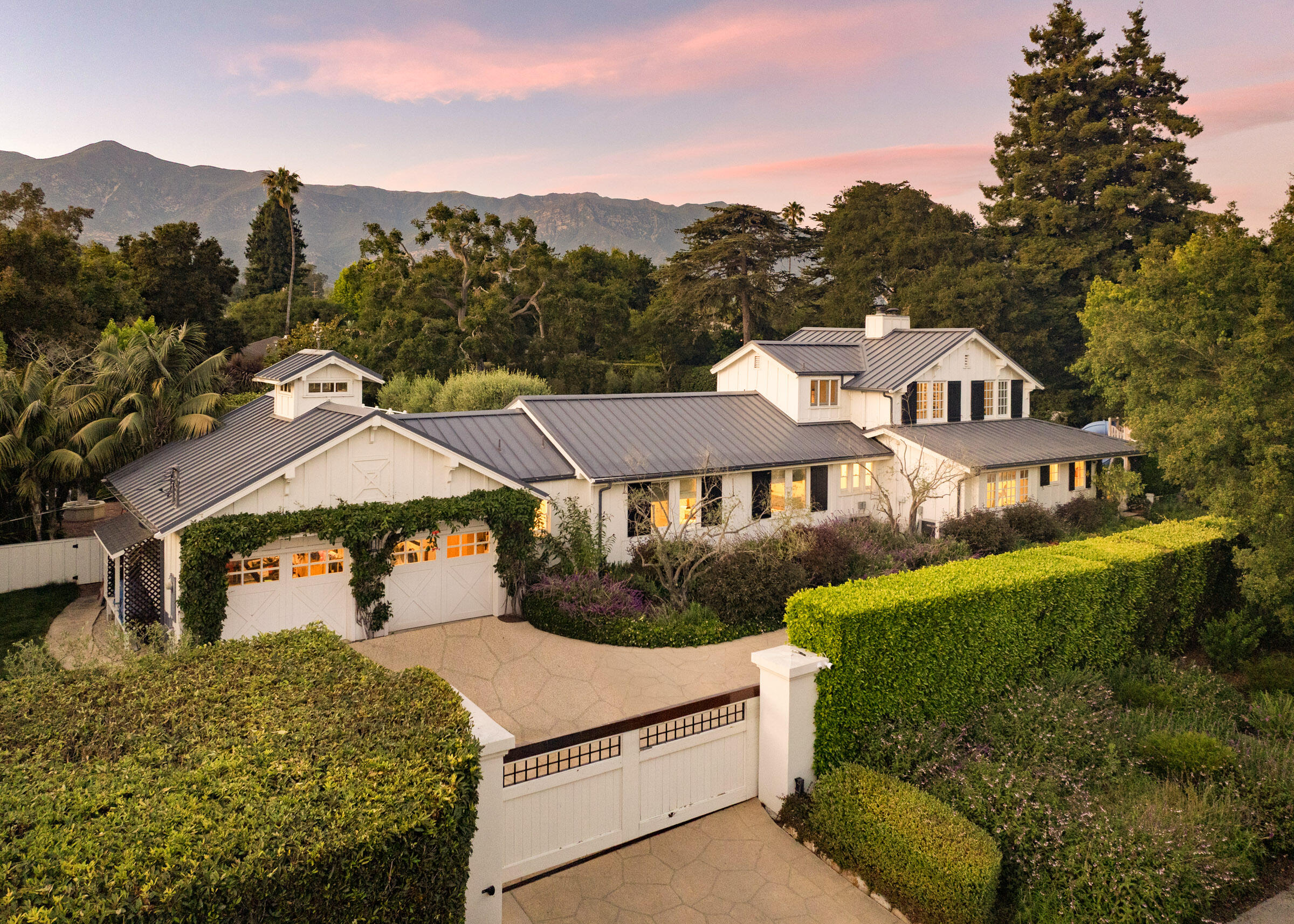 a view of a house with a big yard plants and large trees