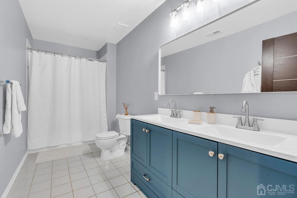 71 Stratton Road Old Bridge, NJ 07747 - Photo 54 of 77 a spacious bathroom with a double vanity sink toilet and a mirror