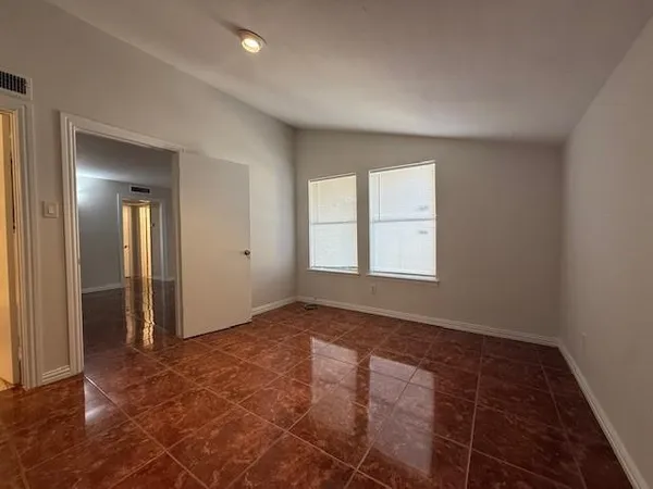 an empty room with windows and closet