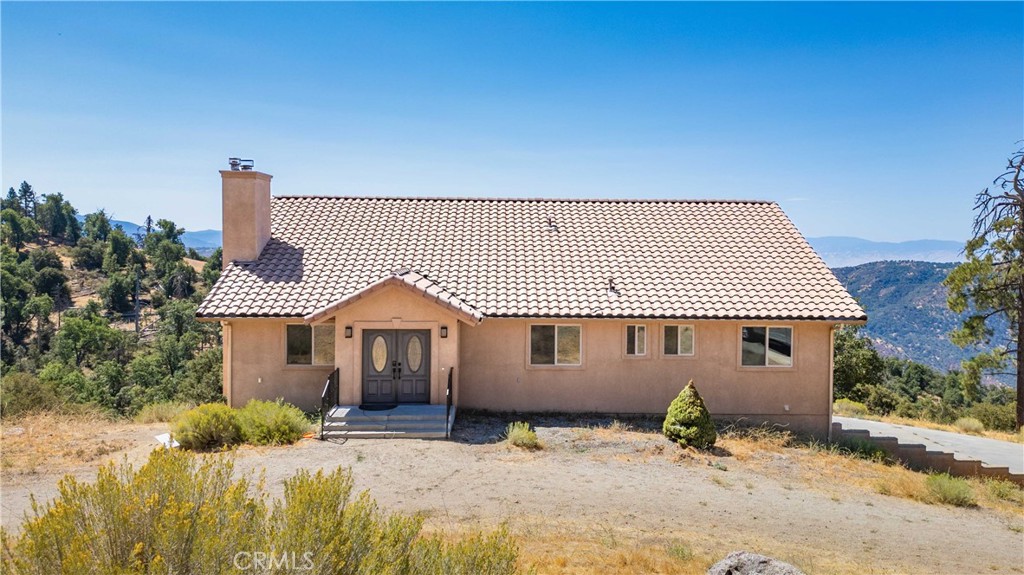 29600 Goldspike Road Tehachapi, CA 93561 - Photo 2 of 48 a front view of a house with a garden