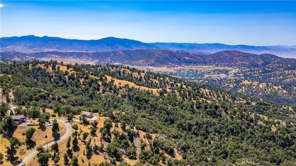 a view of a dry yard with wooden fence