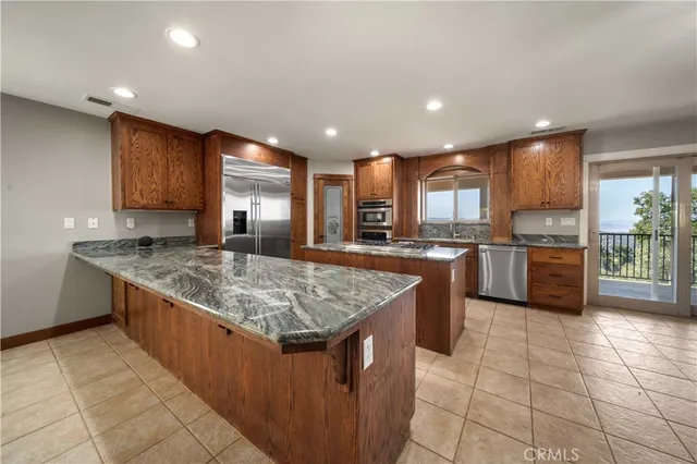 a kitchen with stainless steel appliances granite countertop a stove a sink a oven and a refrigerator