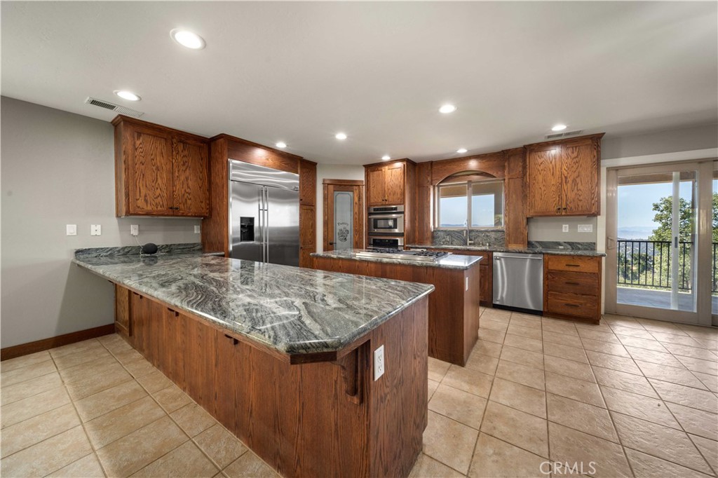 29600 Goldspike Road Tehachapi, CA 93561 - Photo 8 of 48 a kitchen with stainless steel appliances granite countertop a stove a sink a oven and a refrigerator
