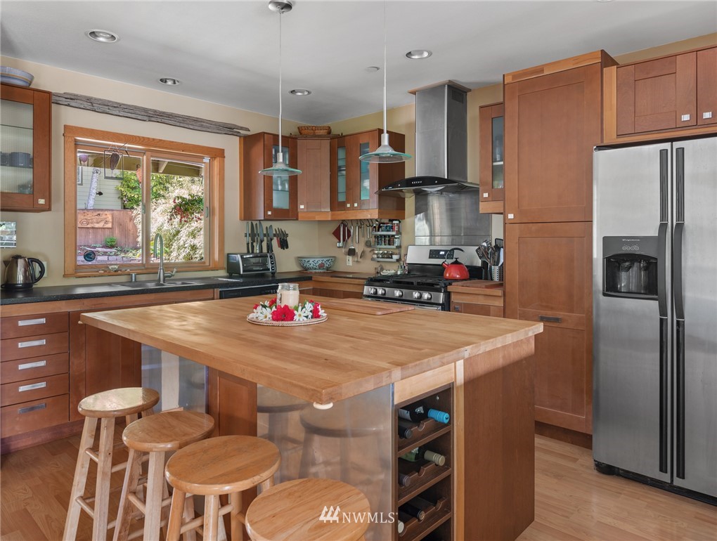 5909 Crescent Beach Road Northwest Vaughn, WA 98394 - Photo 11 of 35 a kitchen with stainless steel appliances granite countertop a sink refrigerator and microwave