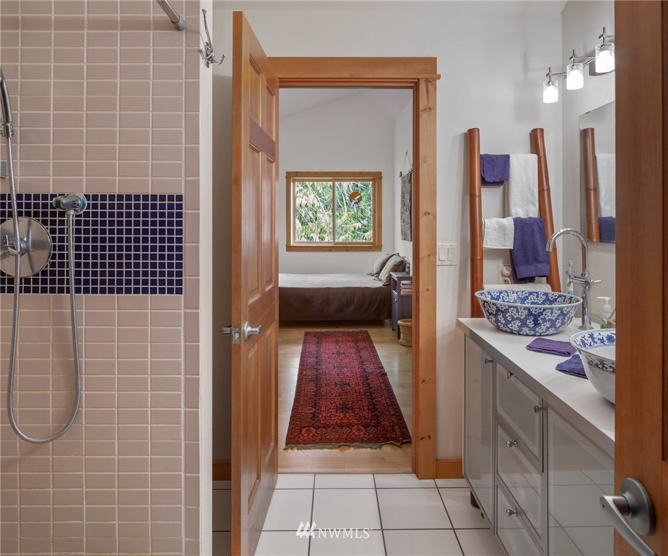 5909 Crescent Beach Road Northwest Vaughn, WA 98394 - Photo 20 of 35 a bathroom with a granite countertop sink a mirror and shower