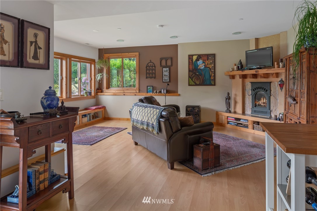 5909 Crescent Beach Road Northwest Vaughn, WA 98394 - Photo 22 of 35 a living room with furniture a flat screen tv and a fireplace