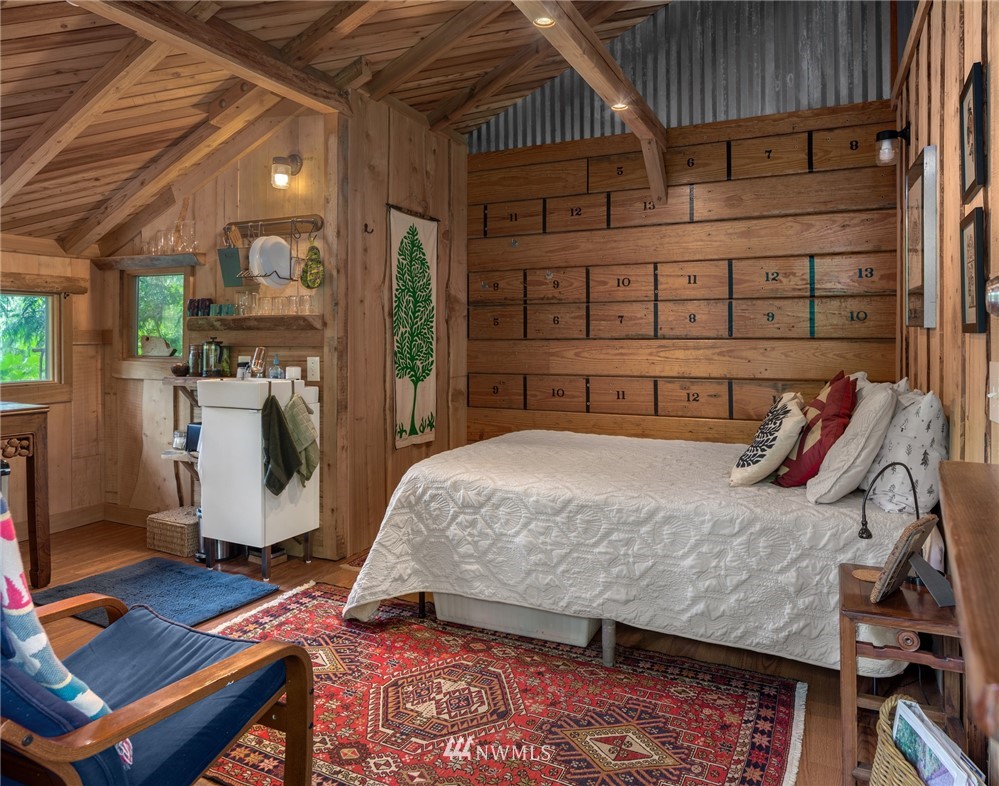 5909 Crescent Beach Road Northwest Vaughn, WA 98394 - Photo 29 of 35 a bedroom with a bed and wooden floor