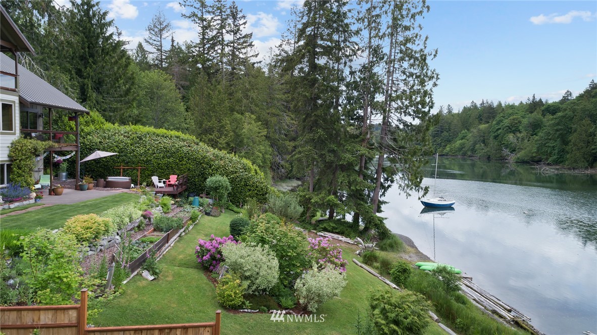 5909 Crescent Beach Road Northwest Vaughn, WA 98394 - Photo 32 of 35 a view of a garden with plants and a bench