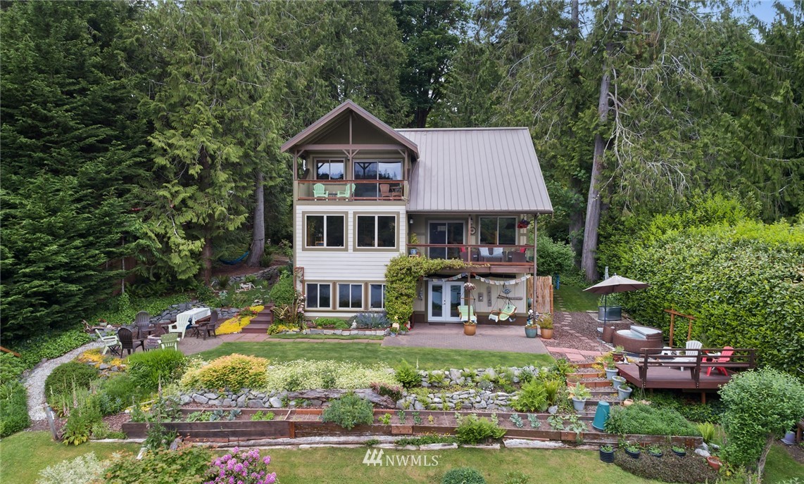 5909 Crescent Beach Road Northwest Vaughn, WA 98394 - Photo 7 of 35 a front view of a house with garden