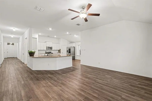 a view of kitchen with kitchen island white cabinetry and wooden floor