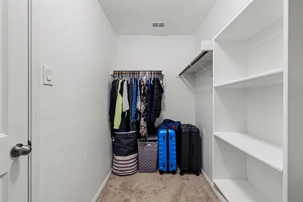 a view of walk in closet with clothes and shoes