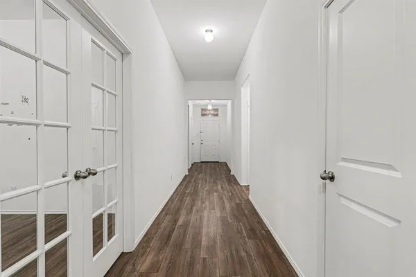a view of a hallway with wooden floor and staircase
