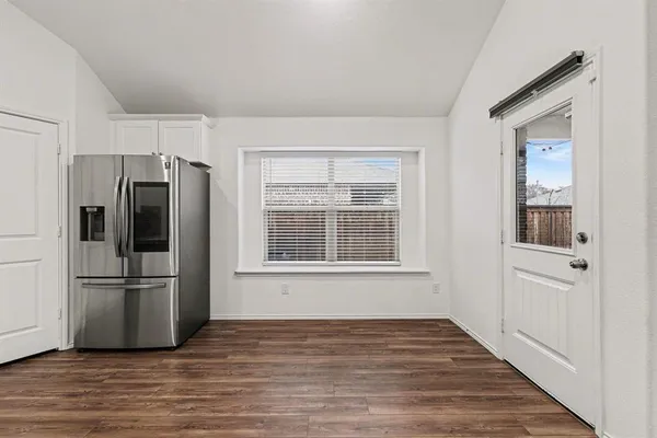 a view of a kitchen with wooden floor and electronic appliances
