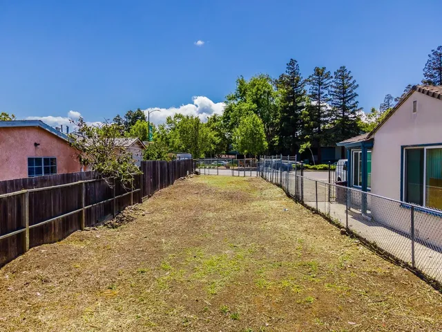 a view of backyard with swimming pool and seating space