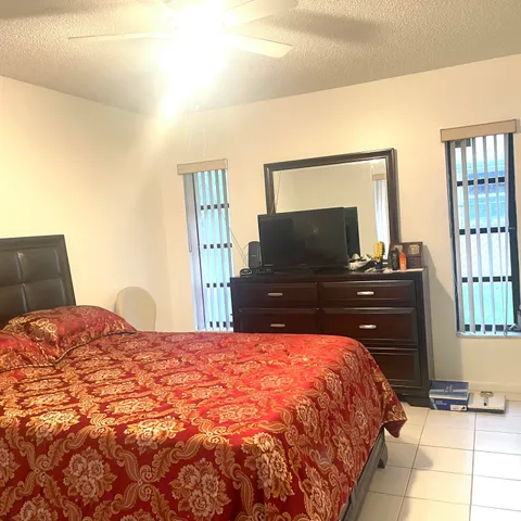 a bedroom with a bed and dresser with mirror