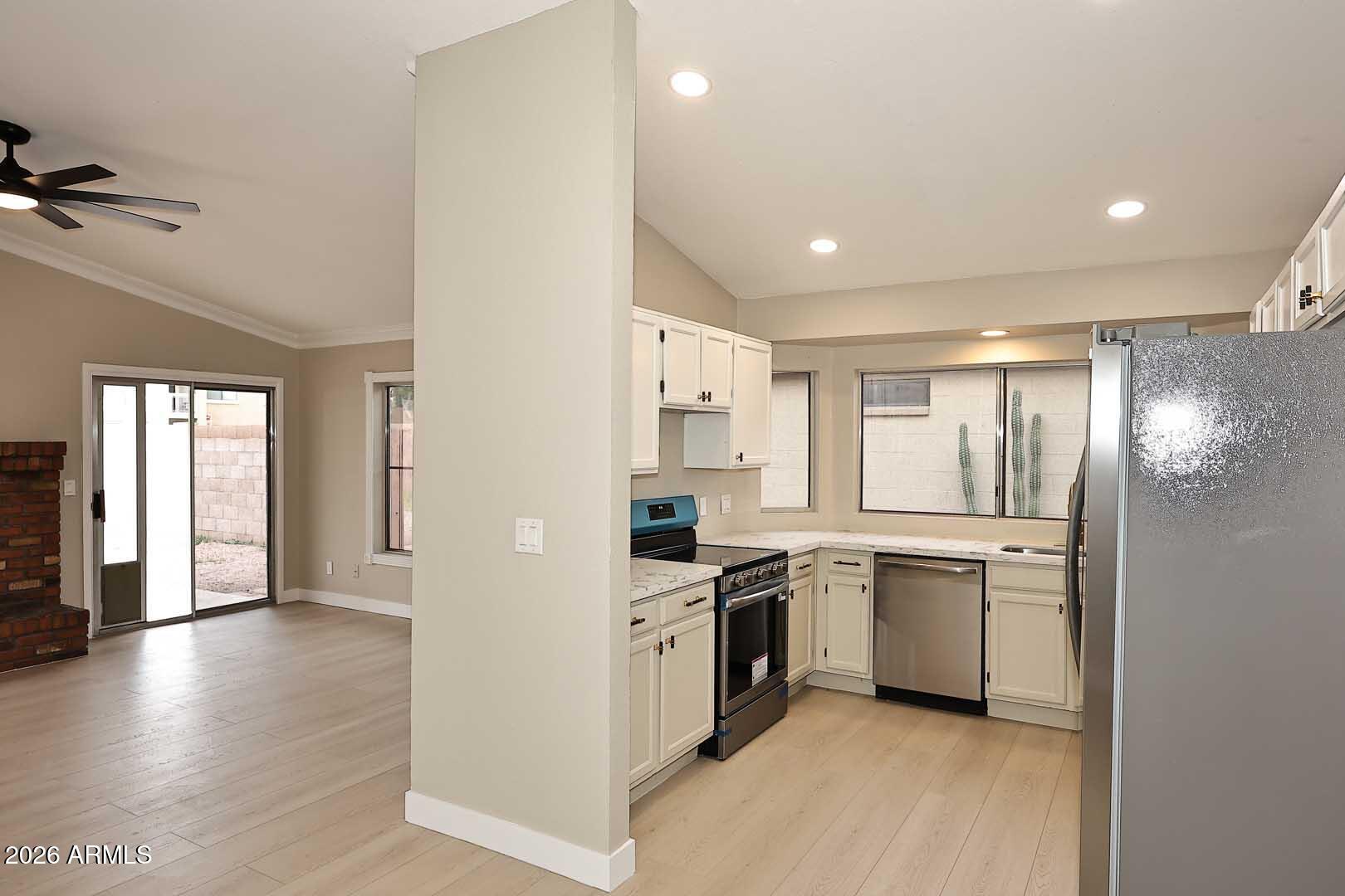 10844 West Ruth Avenue Peoria, AZ 85345 - Photo 11 of 33 a kitchen with stainless steel appliances granite countertop a refrigerator a sink dishwasher a stove and white countertops with wooden floor