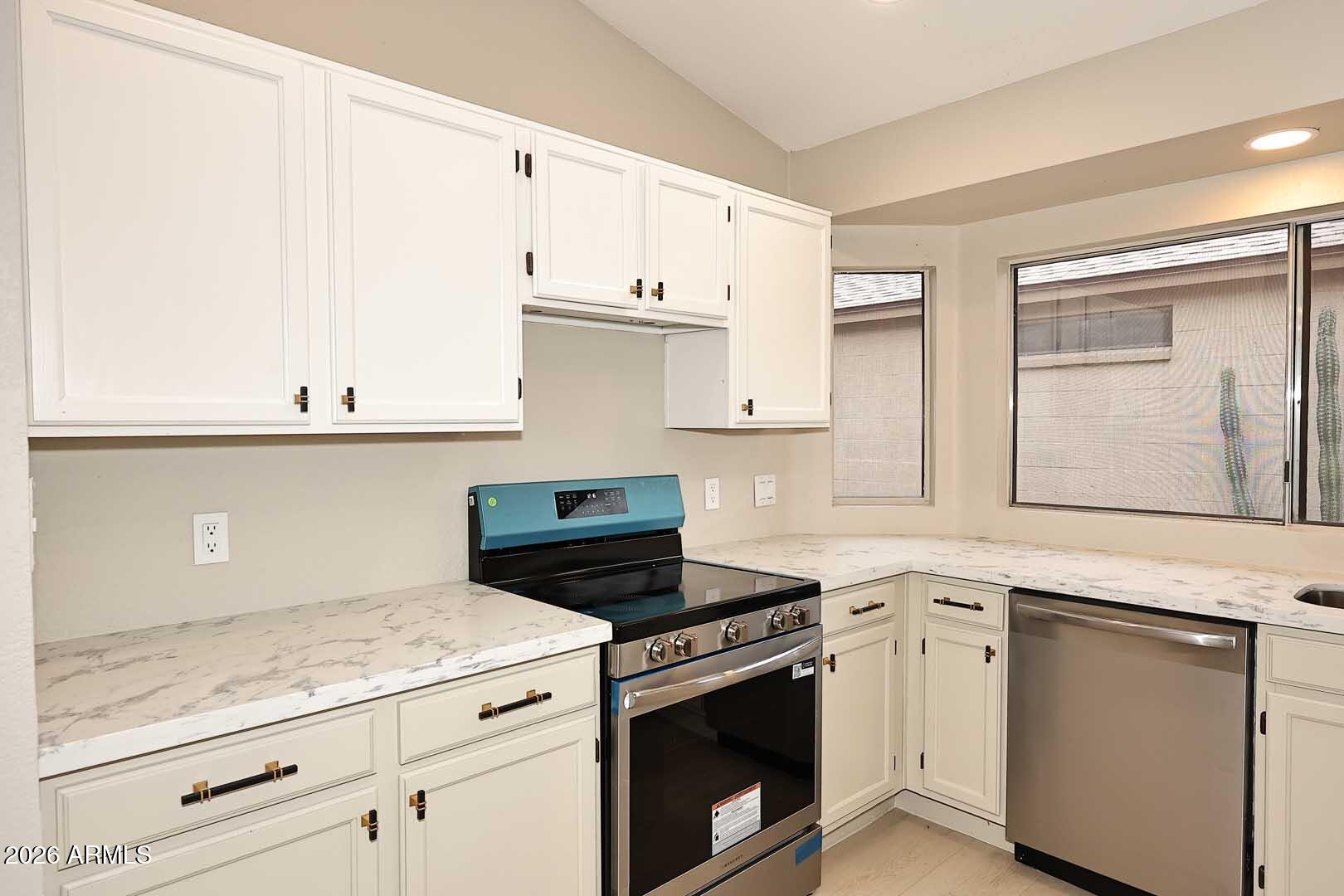 10844 West Ruth Avenue Peoria, AZ 85345 - Photo 12 of 33 a kitchen with granite countertop white cabinets and white appliances
