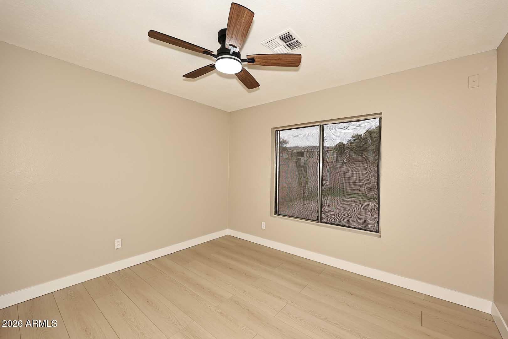10844 West Ruth Avenue Peoria, AZ 85345 - Photo 16 of 33 an empty room with wooden floor fan and windows