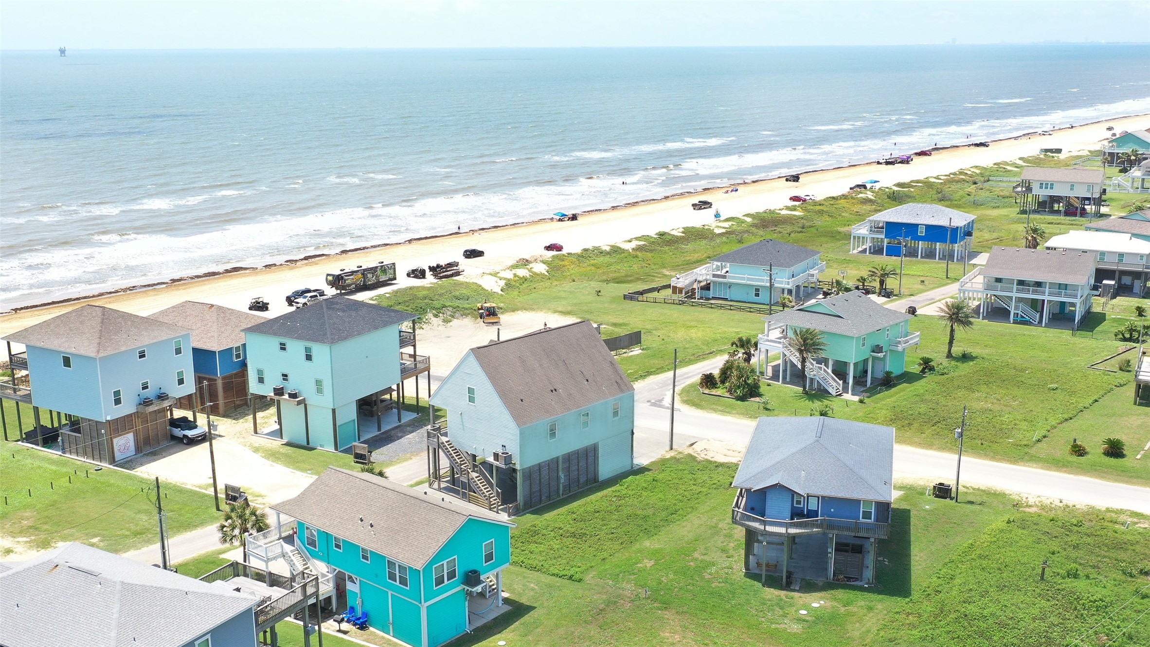 0 Crystal Beach Road Crystal Beach, TX 77650 - Photo 12 of 18 This photo showcases a coastal neighborhood with stilted beach houses offering direct ocean views and easy access to the sandy beach. The homes are brightly colored, adding to the charming seaside ambiance. Perfect for those seeking a relaxing beachfront lifestyle.