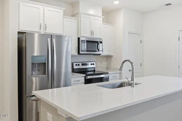a kitchen with stainless steel appliances a refrigerator sink and microwave