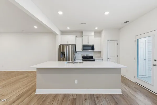 a kitchen with kitchen island a sink appliances and cabinets