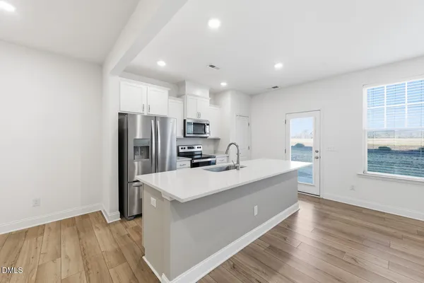 a kitchen with stainless steel appliances a stove microwave and sink