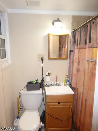 a bathroom with a toilet a sink and mirror