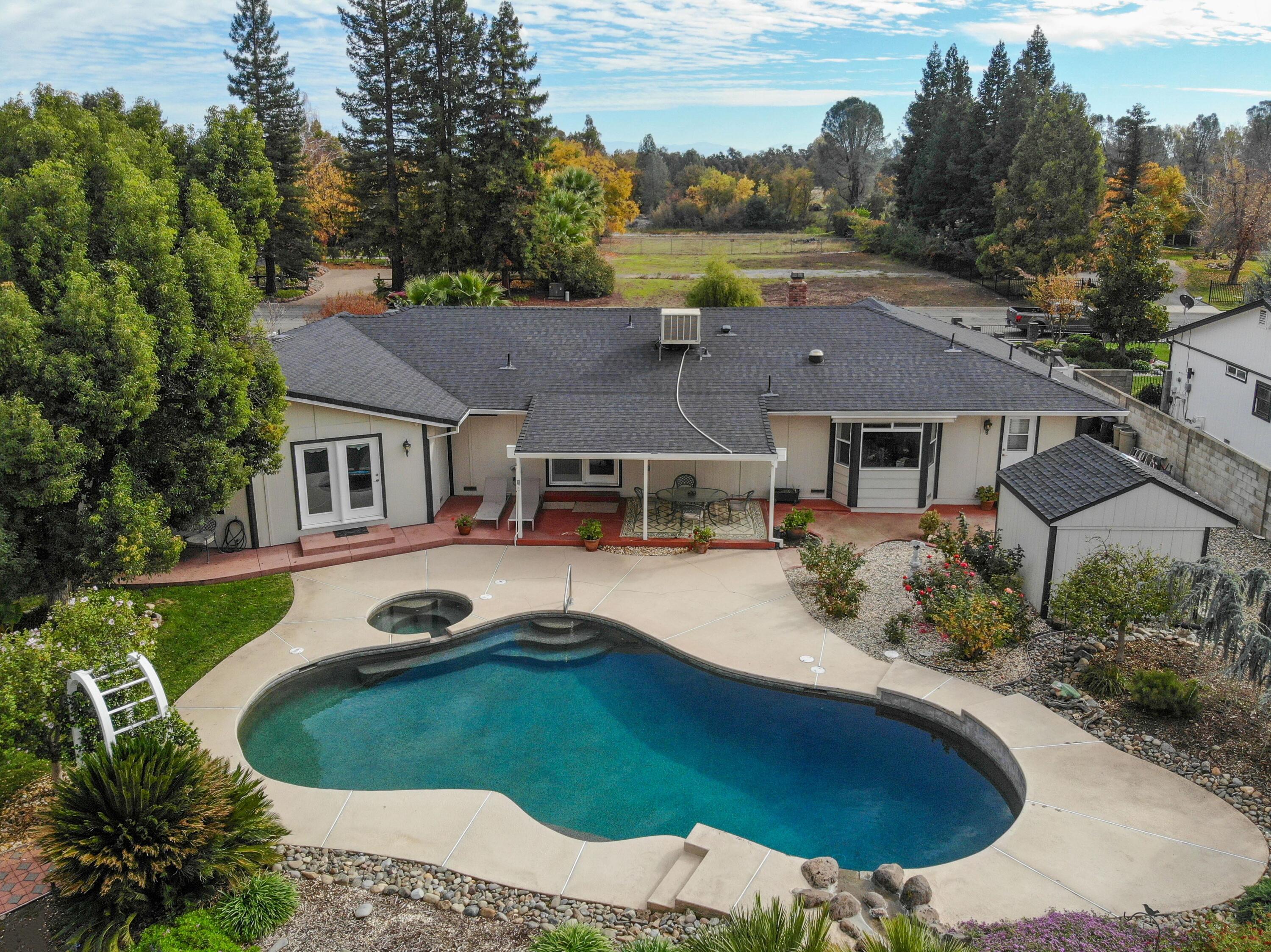 5956 Riverside Drive Redding, CA 96001 - Photo 3 of 54 an aerial view of a house with swimming pool and garden