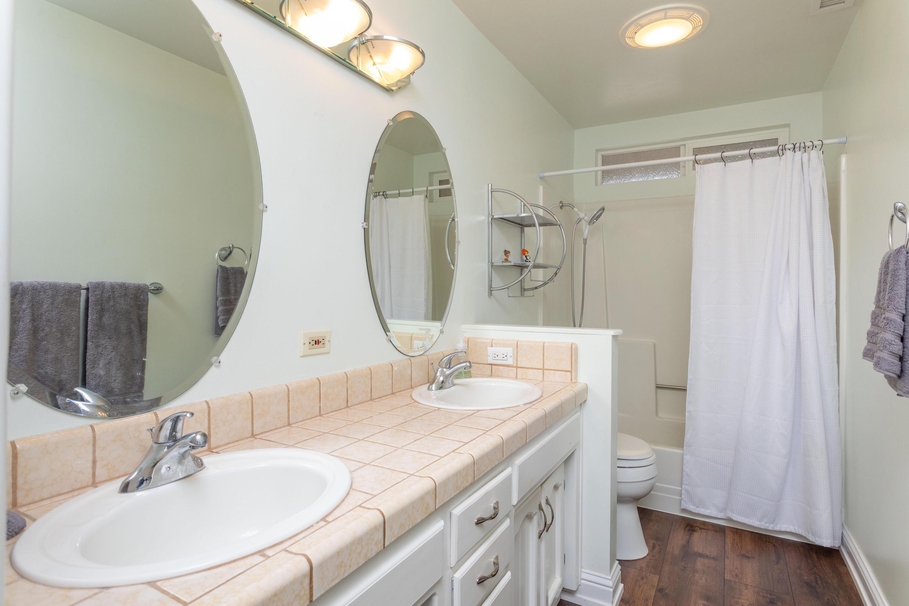 5956 Riverside Drive Redding, CA 96001 - Photo 35 of 54 a bathroom with a granite countertop sink a toilet and a mirror
