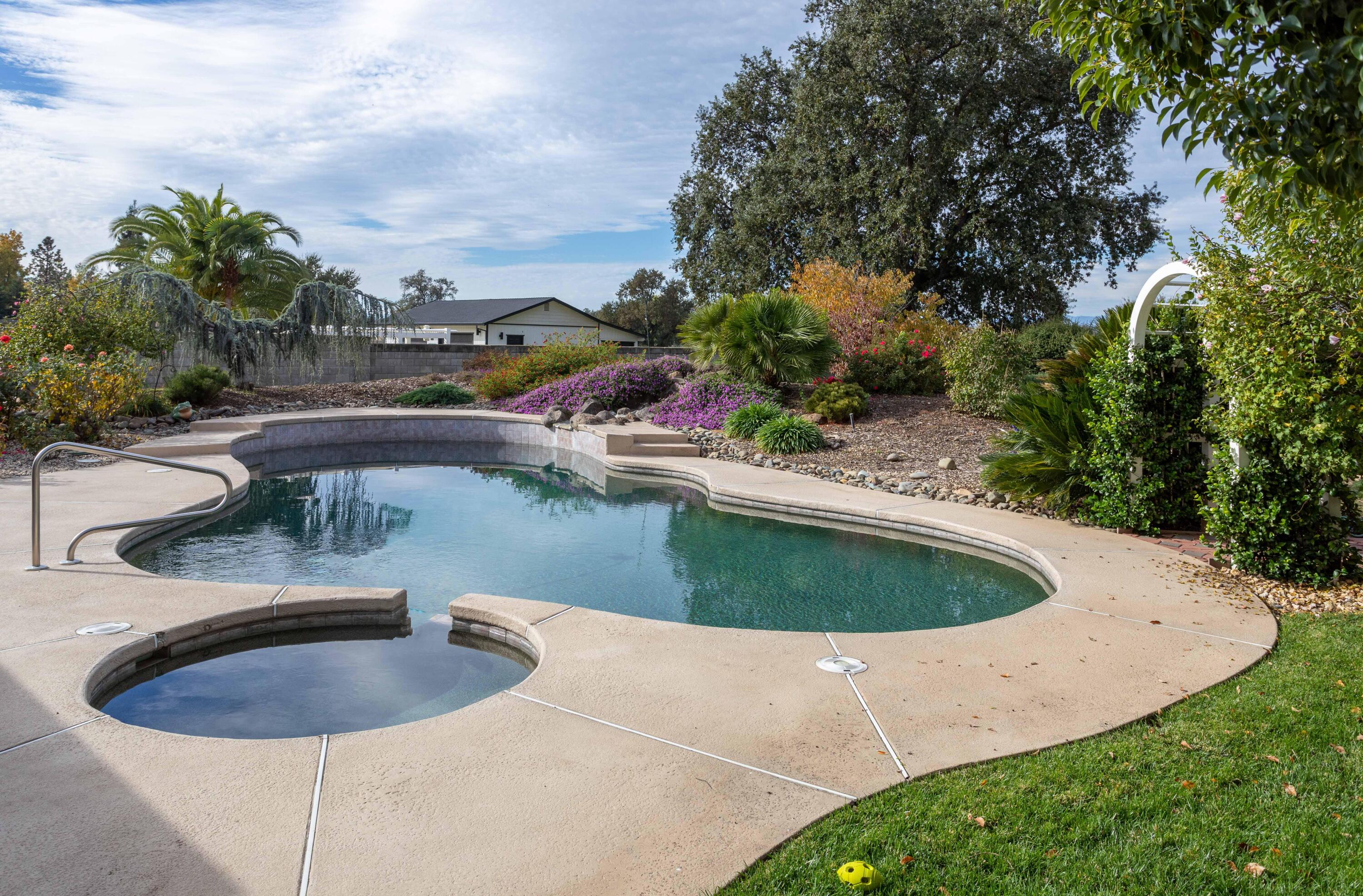 5956 Riverside Drive Redding, CA 96001 - Photo 47 of 54 a view of a swimming pool with a yard and trees
