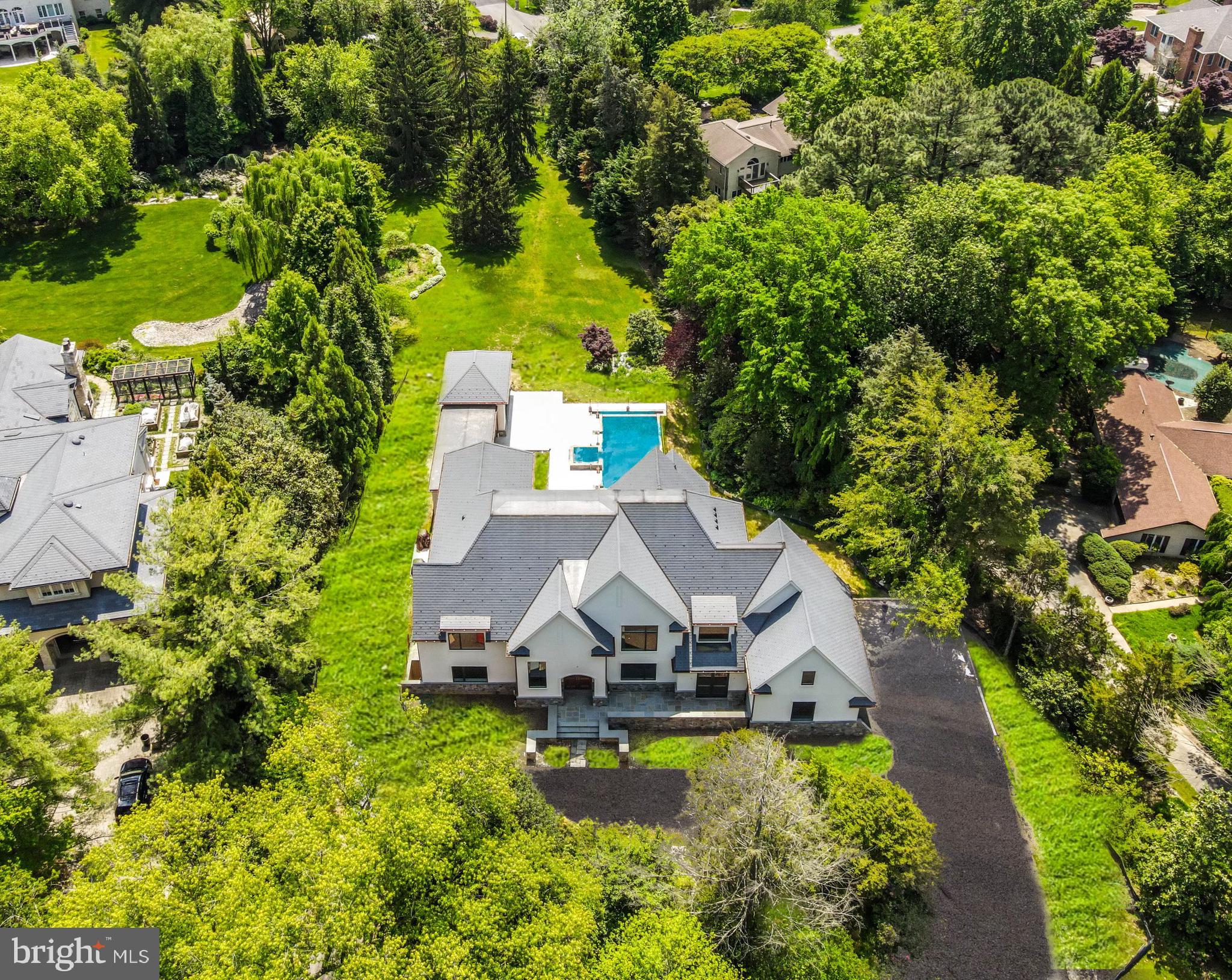 an aerial view of a house with swimming pool a yard and outdoor seating