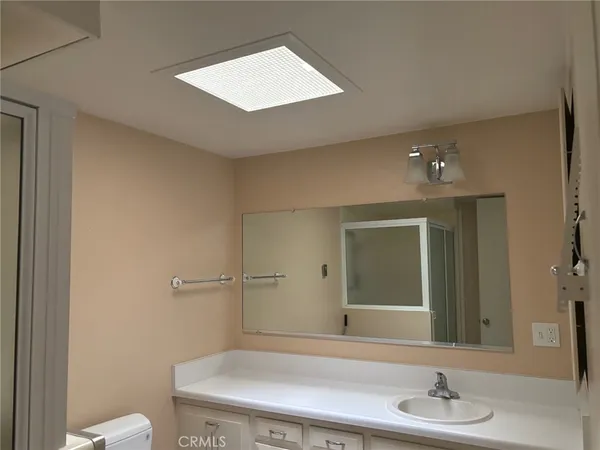 a bathroom with a sink a toilet and mirror