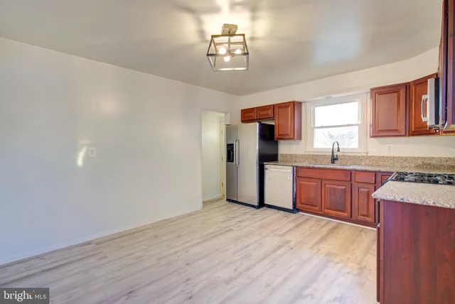 a kitchen with granite countertop a refrigerator and a sink