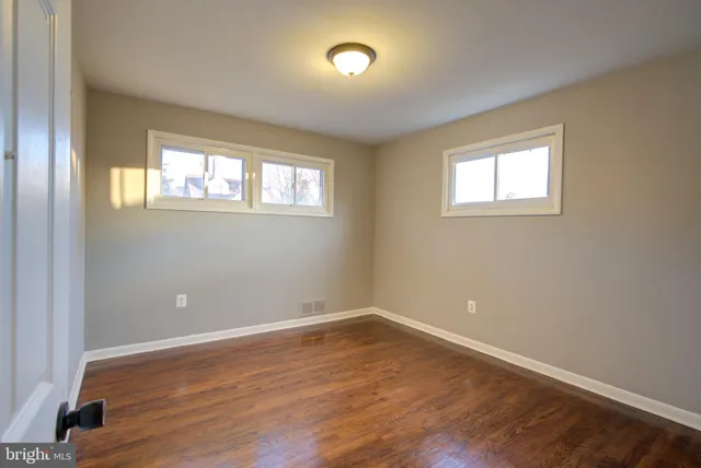 a view of a room with wooden floor and windows