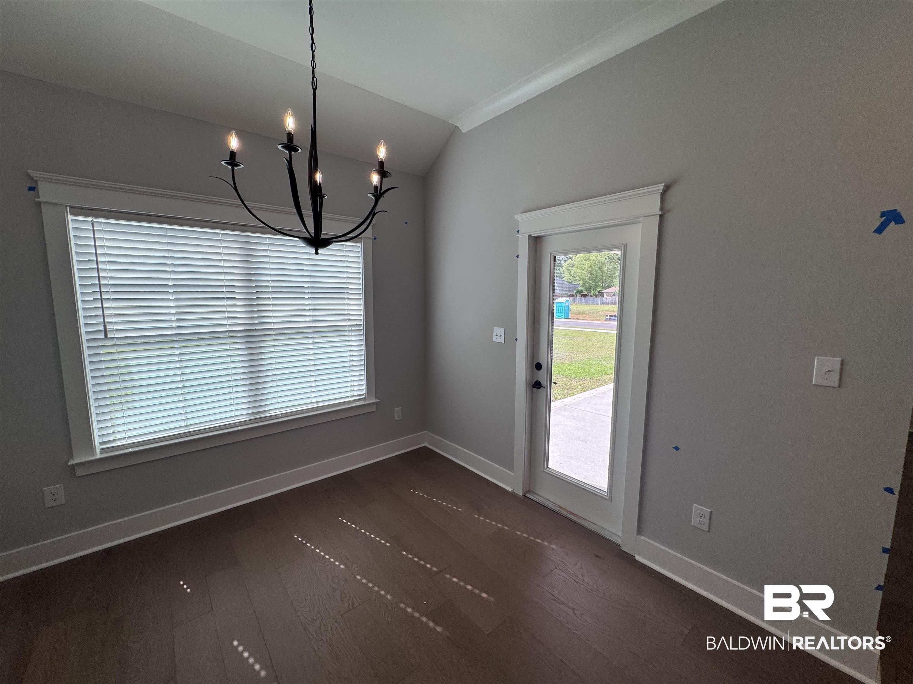 27371 Patch Pl Loop Daphne, AL 36526 - Photo 29 of 63 Unfurnished dining area with dark wood-style floors, crown molding, a chandelier, and vaulted ceiling