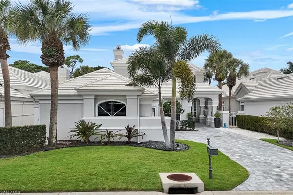 a front view of a house with a garden and yard